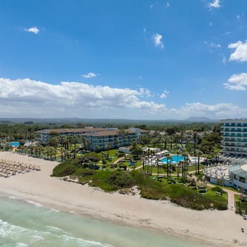 a beach with a group of buildings and a body of water