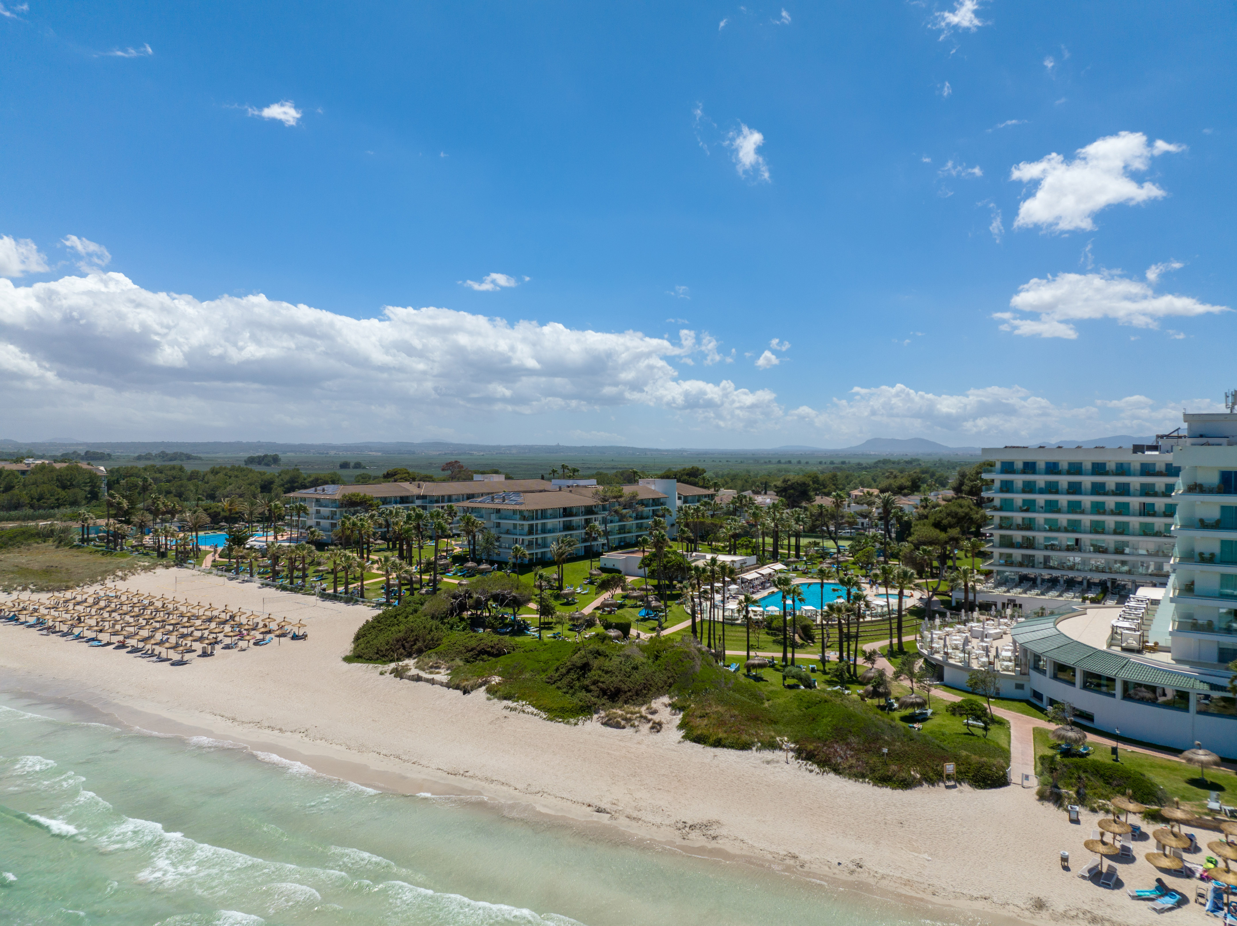 a beach with a group of buildings and a body of water