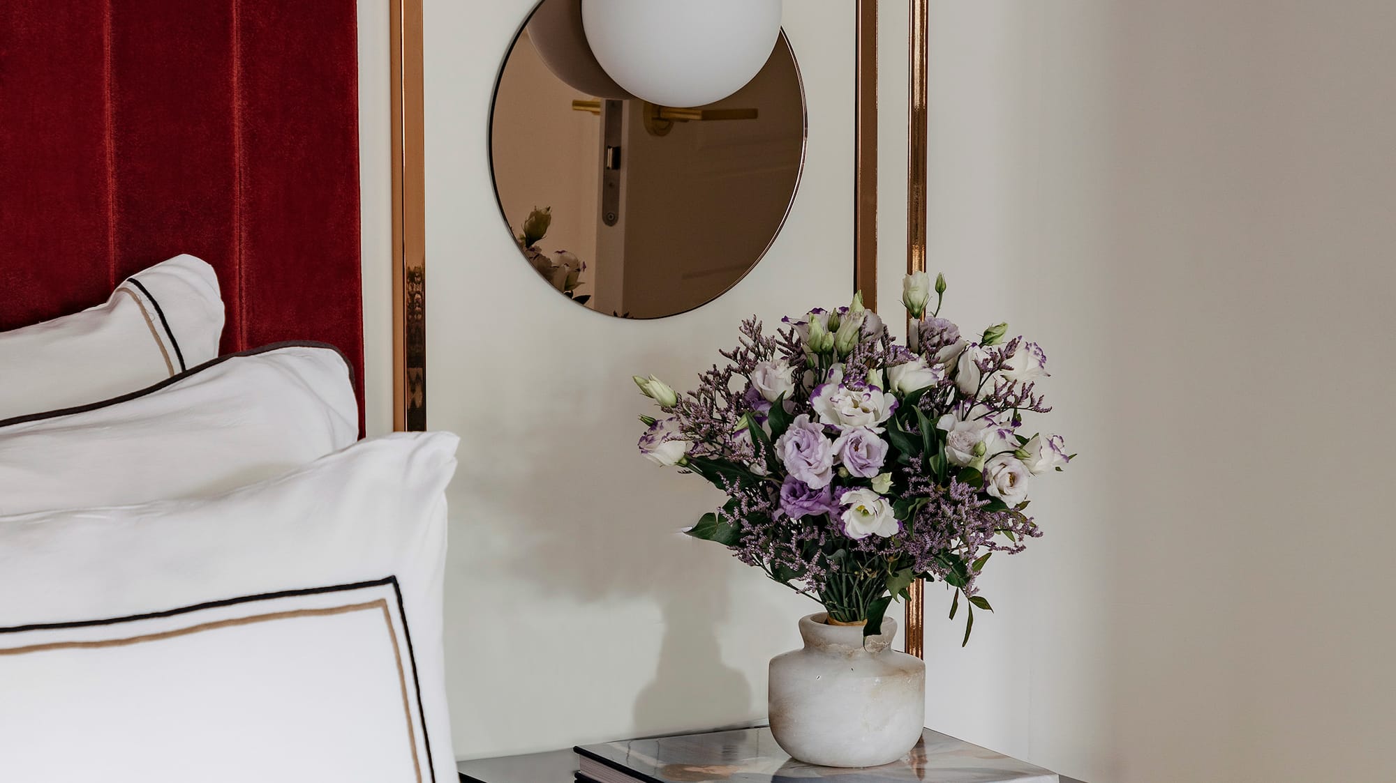 a vase of flowers on a table next to a mirror