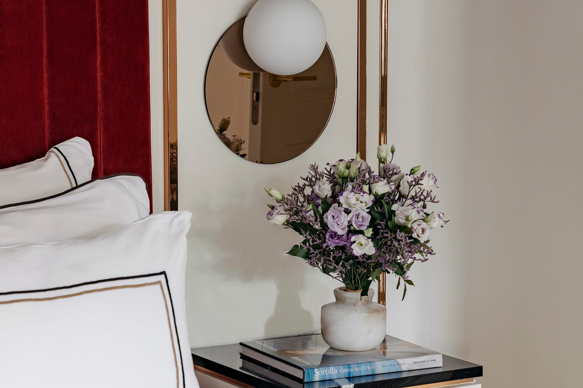 a vase of flowers on a table next to a mirror