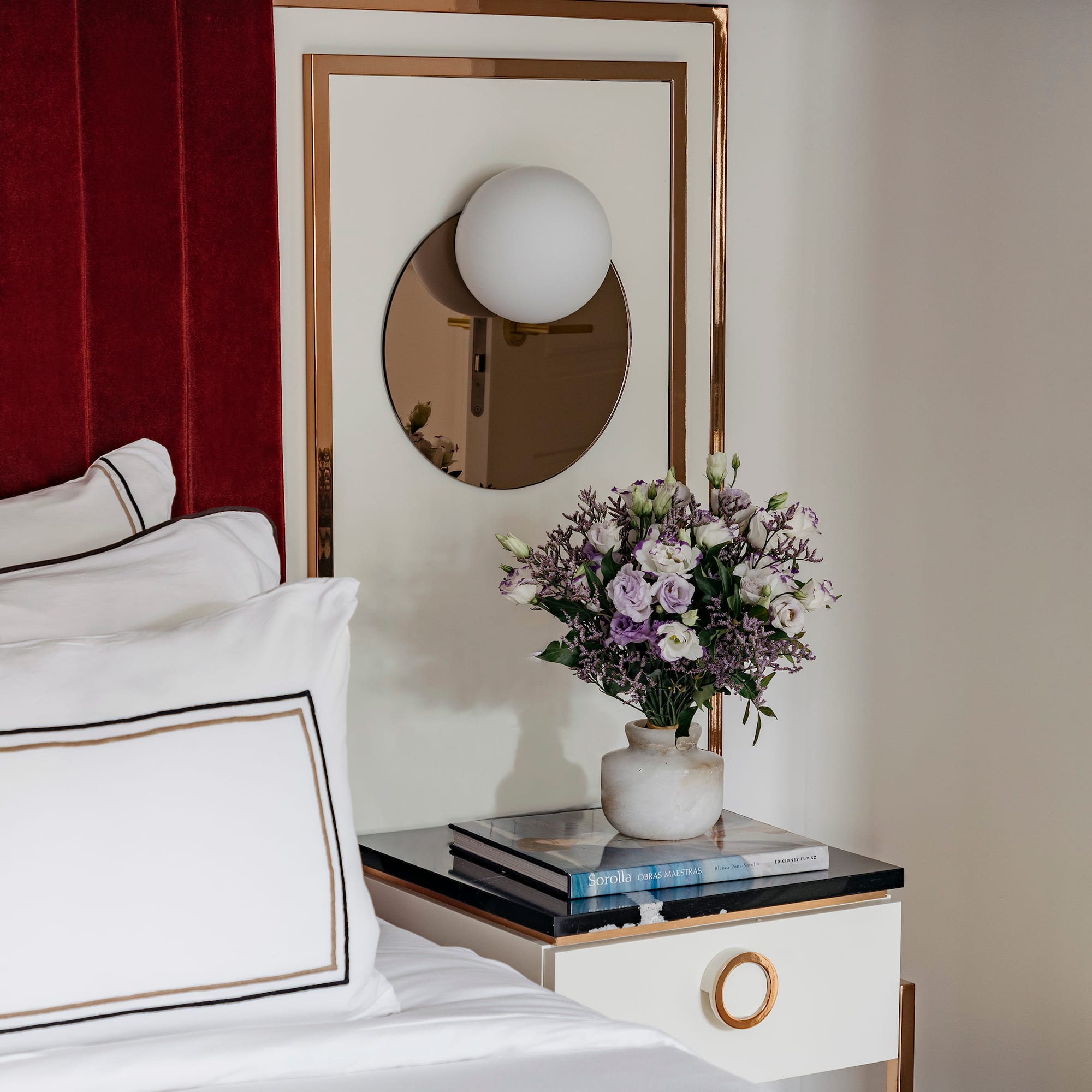 a vase of flowers on a table next to a mirror