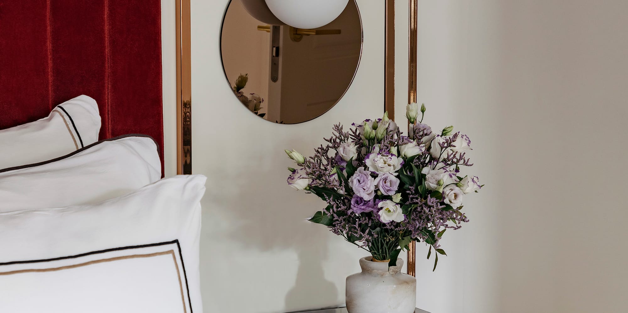 a vase of flowers on a table next to a mirror