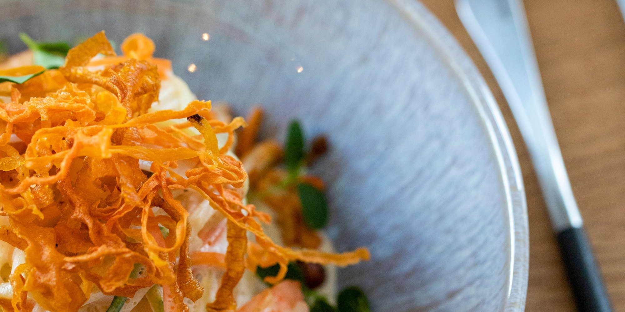 a bowl of noodles with shrimp and vegetables
