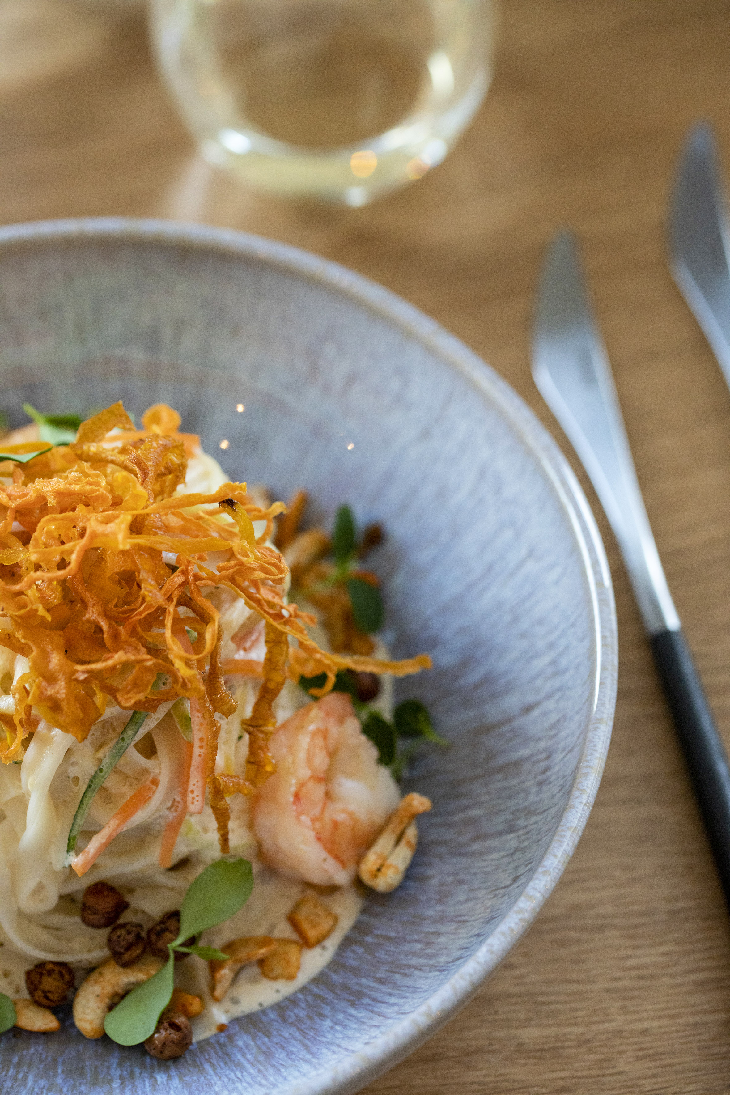 Gourmet shrimp noodle dish with crispy garnish, nuts, and fresh greens. - De Gaart, Cuisine locale - INNSiDE Luxembourg, Luxembourg