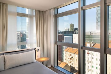 a bedroom with a bed and a table and a window