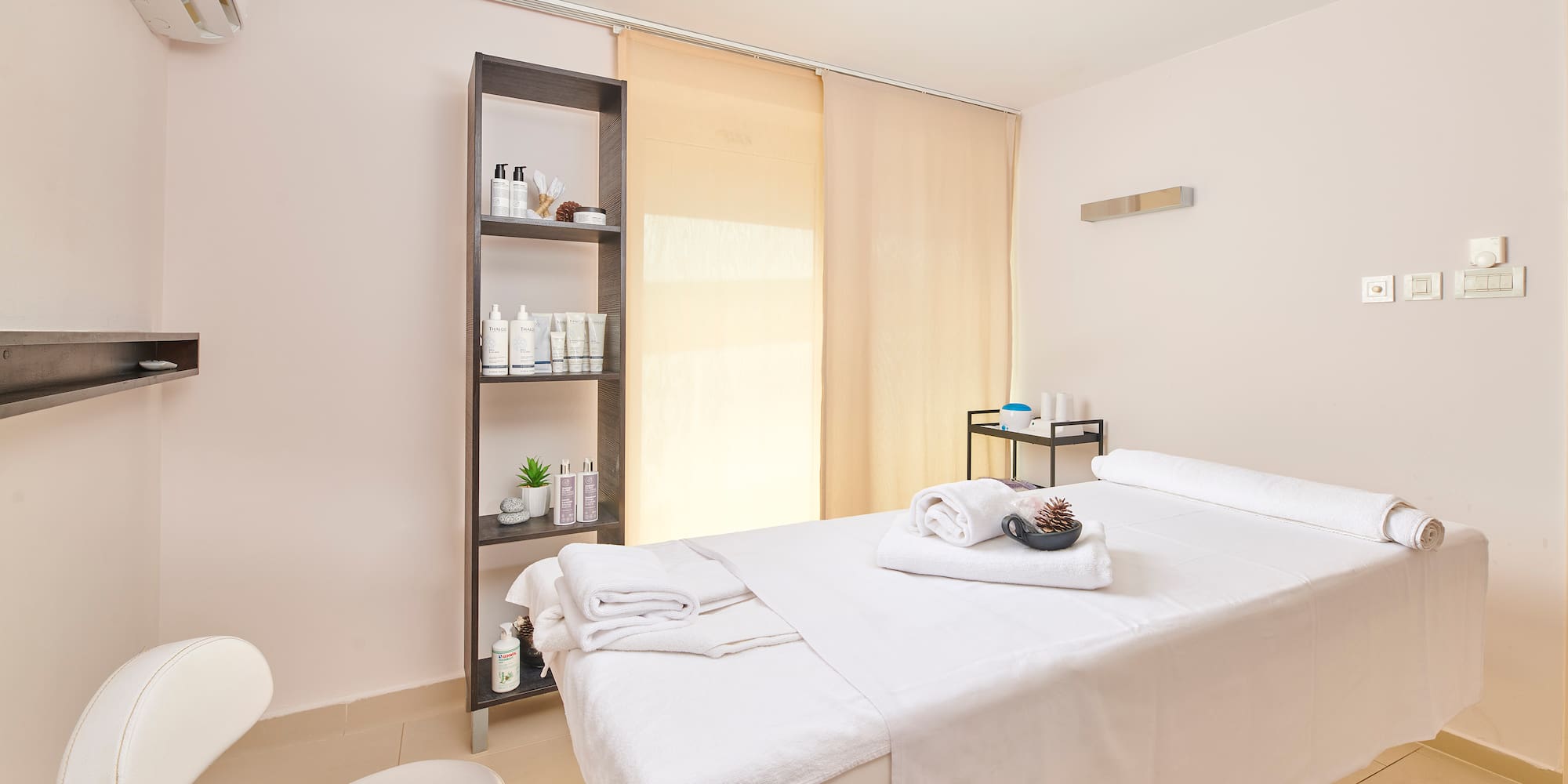 a massage room with a white bed and toilet