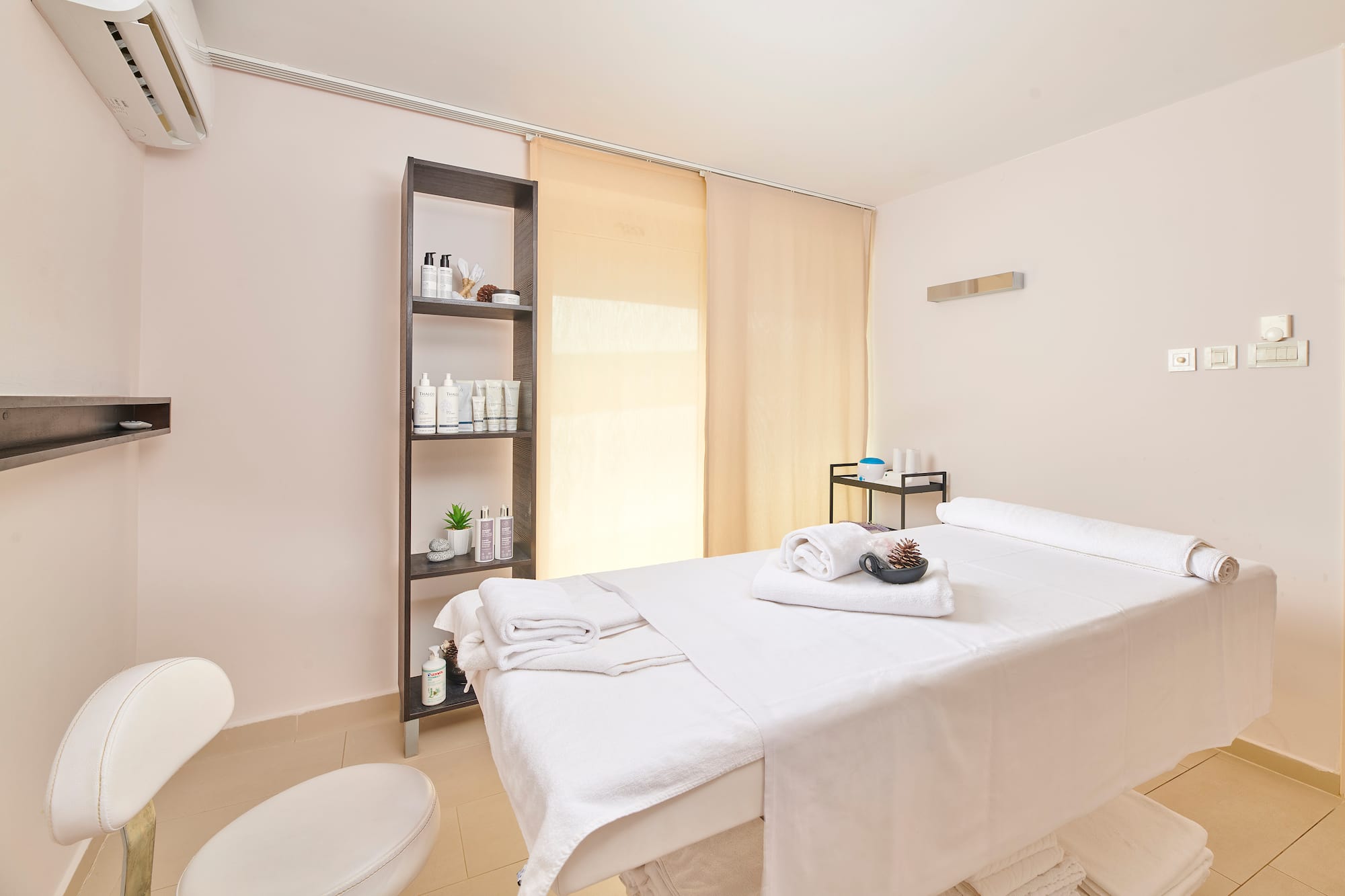 a massage room with a white bed and toilet