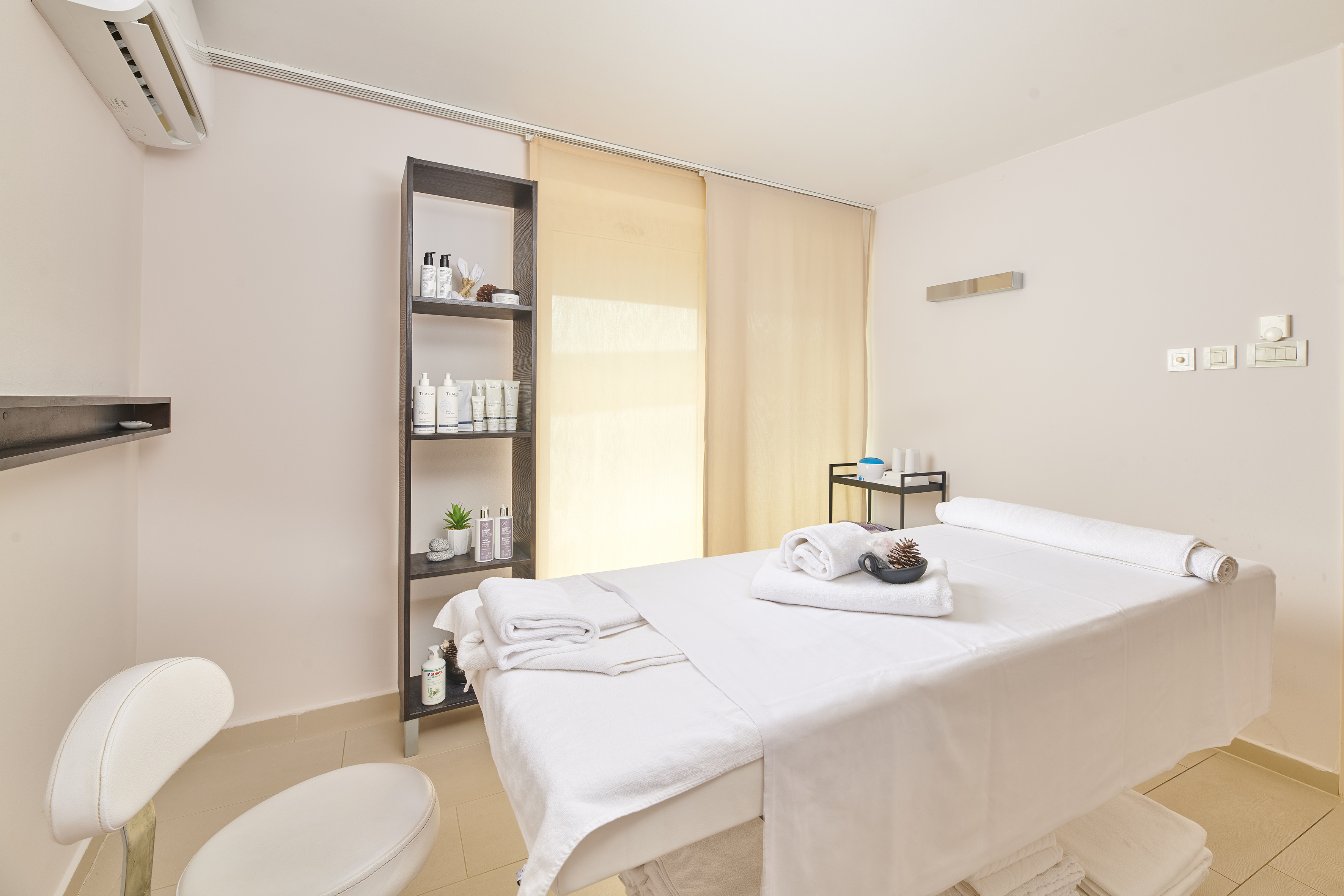 a massage room with a white bed and toilet