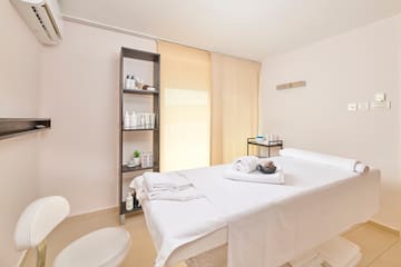 a massage room with a white bed and toilet
