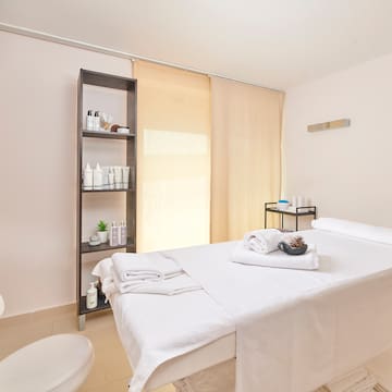 a massage room with a white bed and toilet