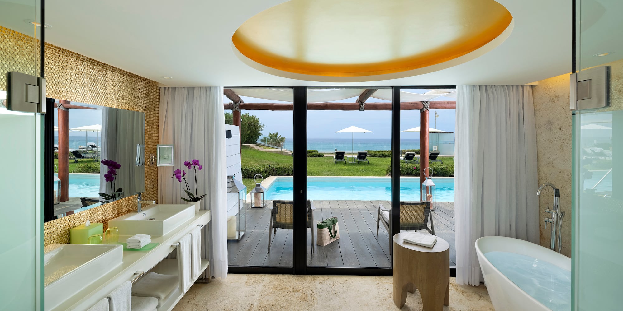 Luxury resort bathroom with private pool, ocean view, and freestanding tub.