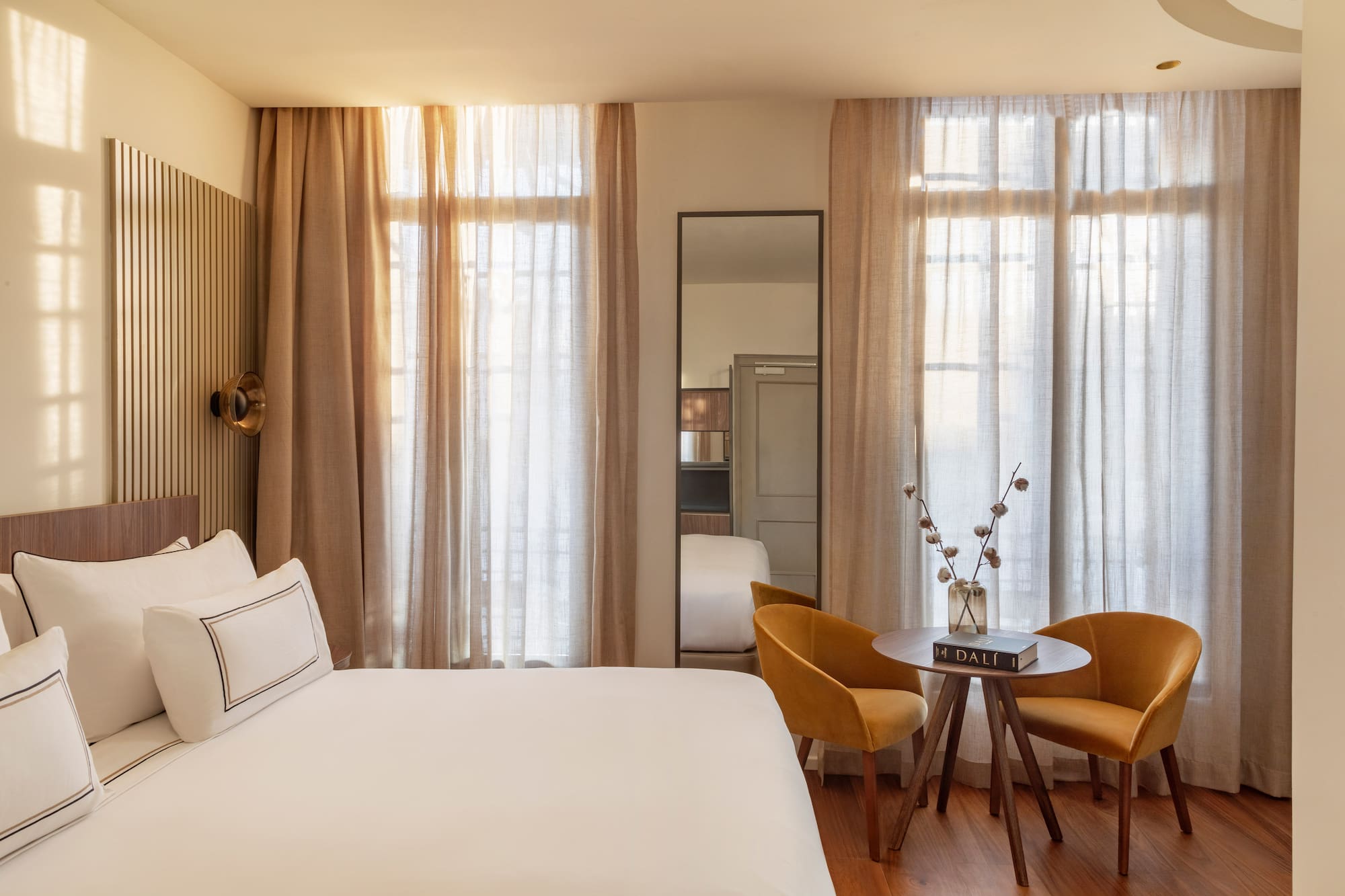 a room with a bed and chairs