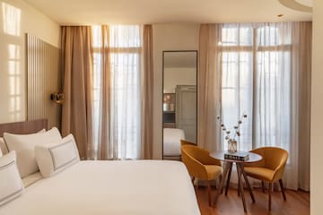 a room with a bed and chairs