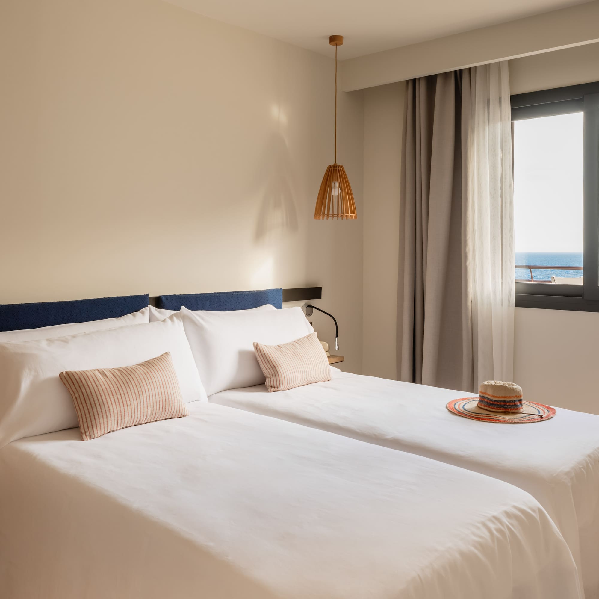 a room with two beds and a hat on the side