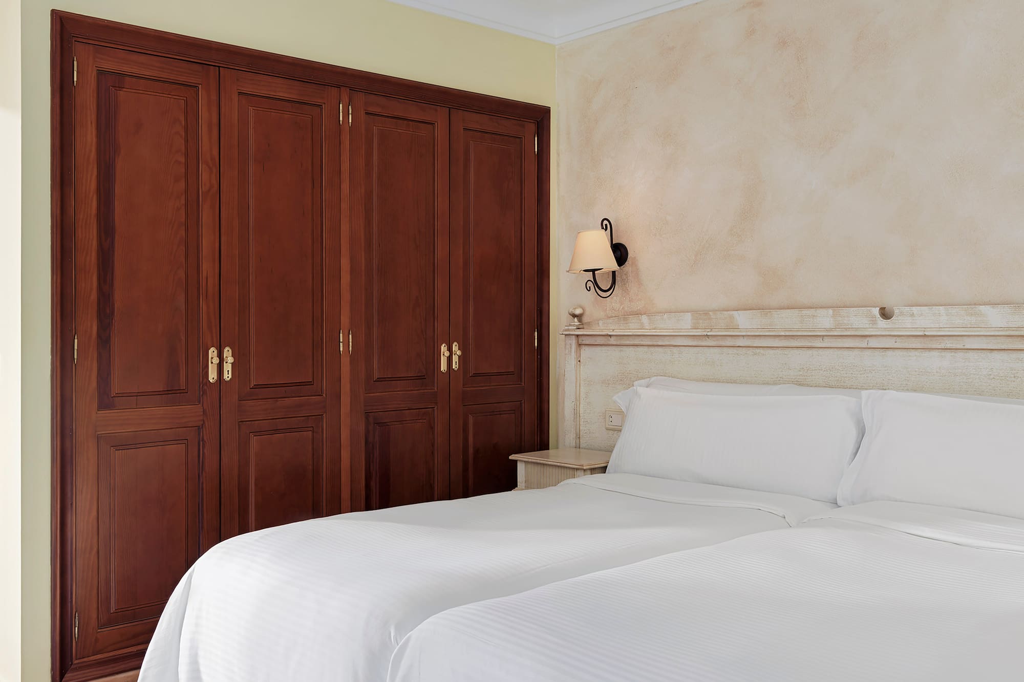 a room with two beds and a ceiling fan