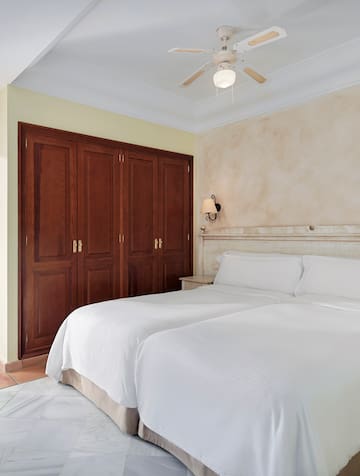 a room with two beds and a ceiling fan