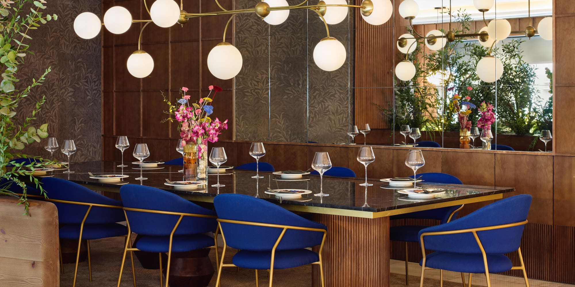 a dining room with a chandelier and blue chairs