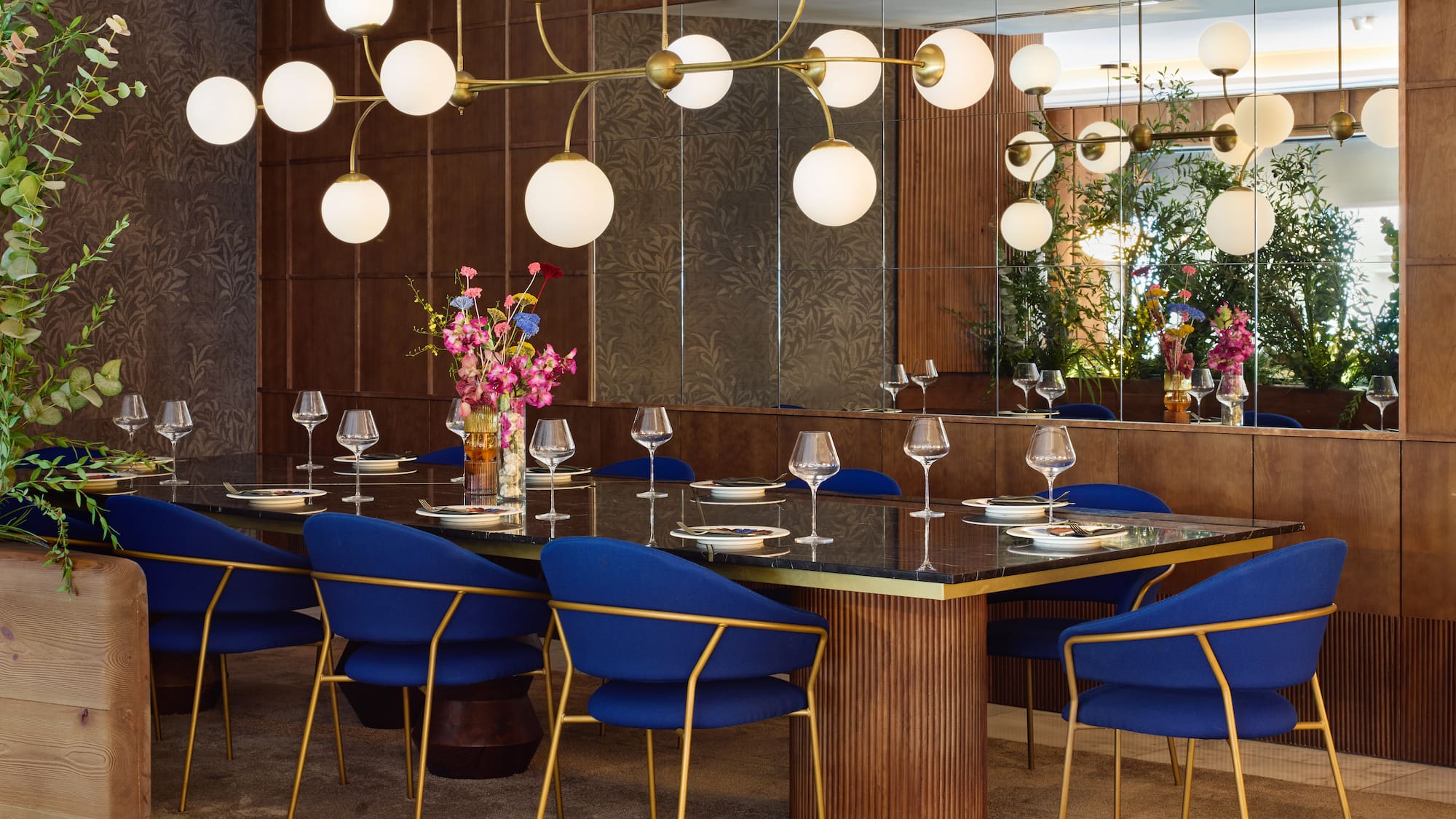 a dining room with a chandelier and blue chairs