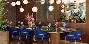 a dining room with a chandelier and blue chairs