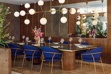 a dining room with a chandelier and blue chairs