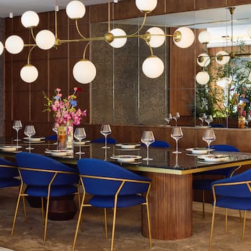 a dining room with a chandelier and blue chairs