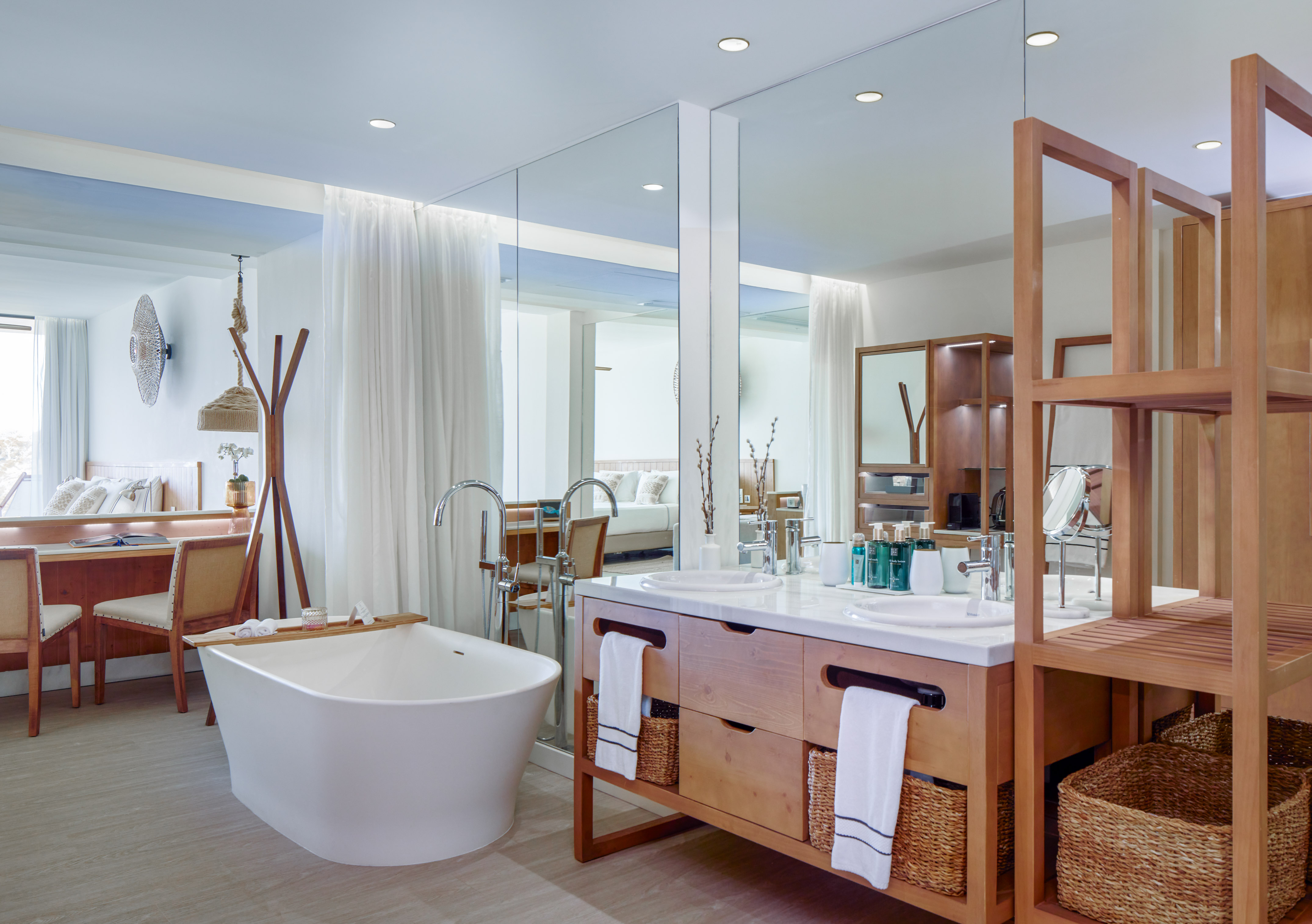 Bright, modern hotel bathroom with freestanding tub, double wood vanity.