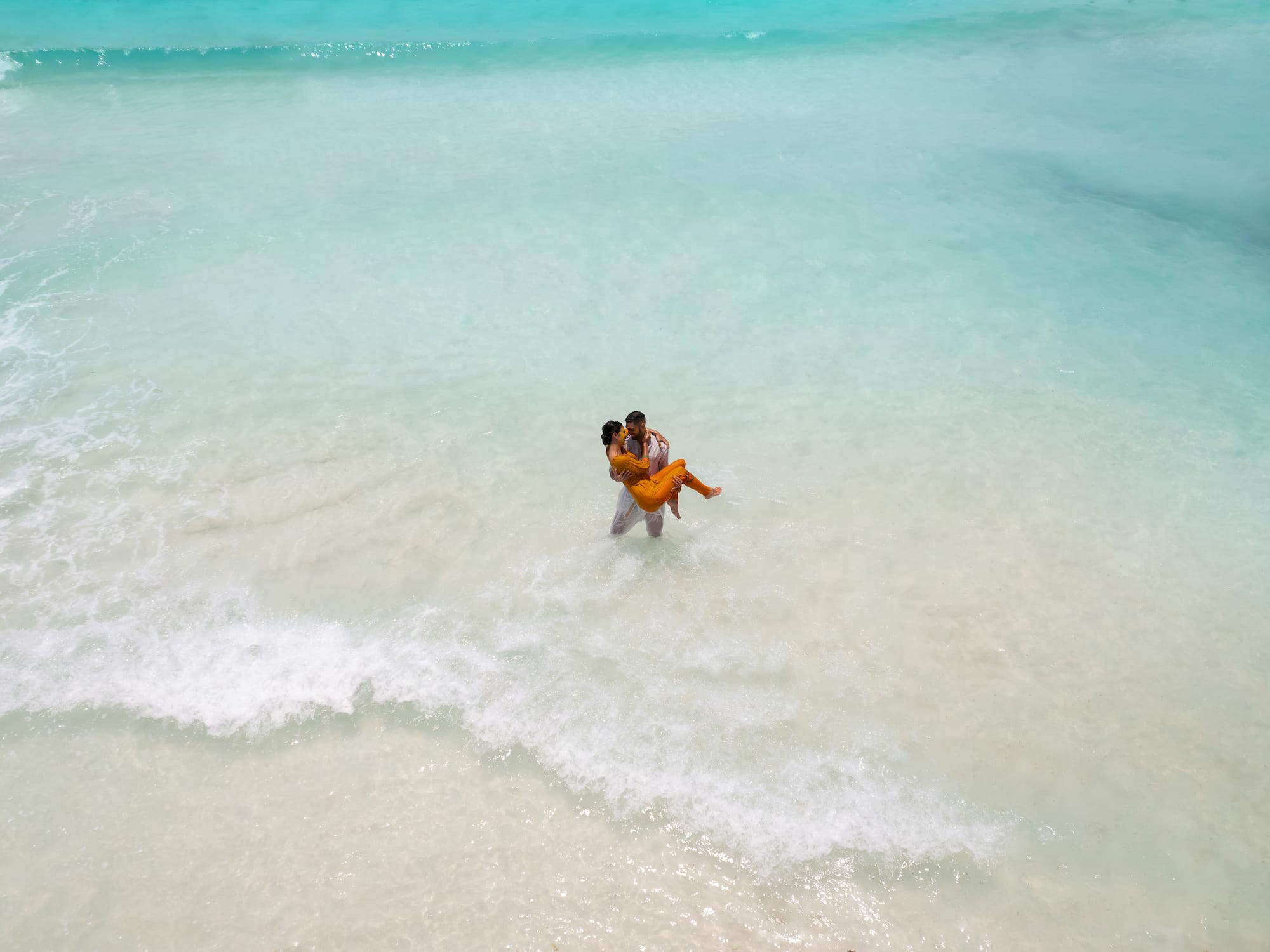 a man carrying a woman in the water