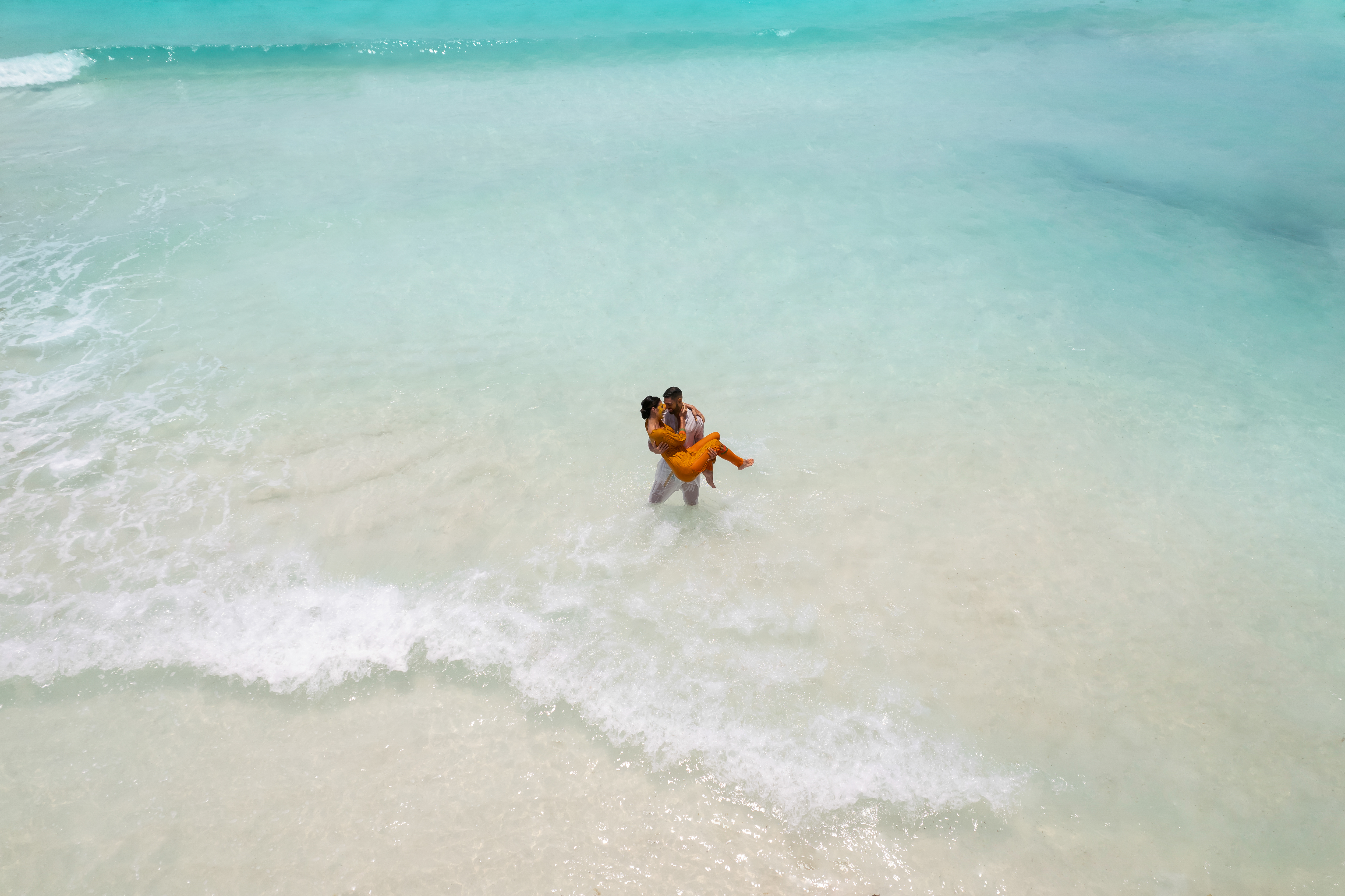 a man carrying a woman in the water