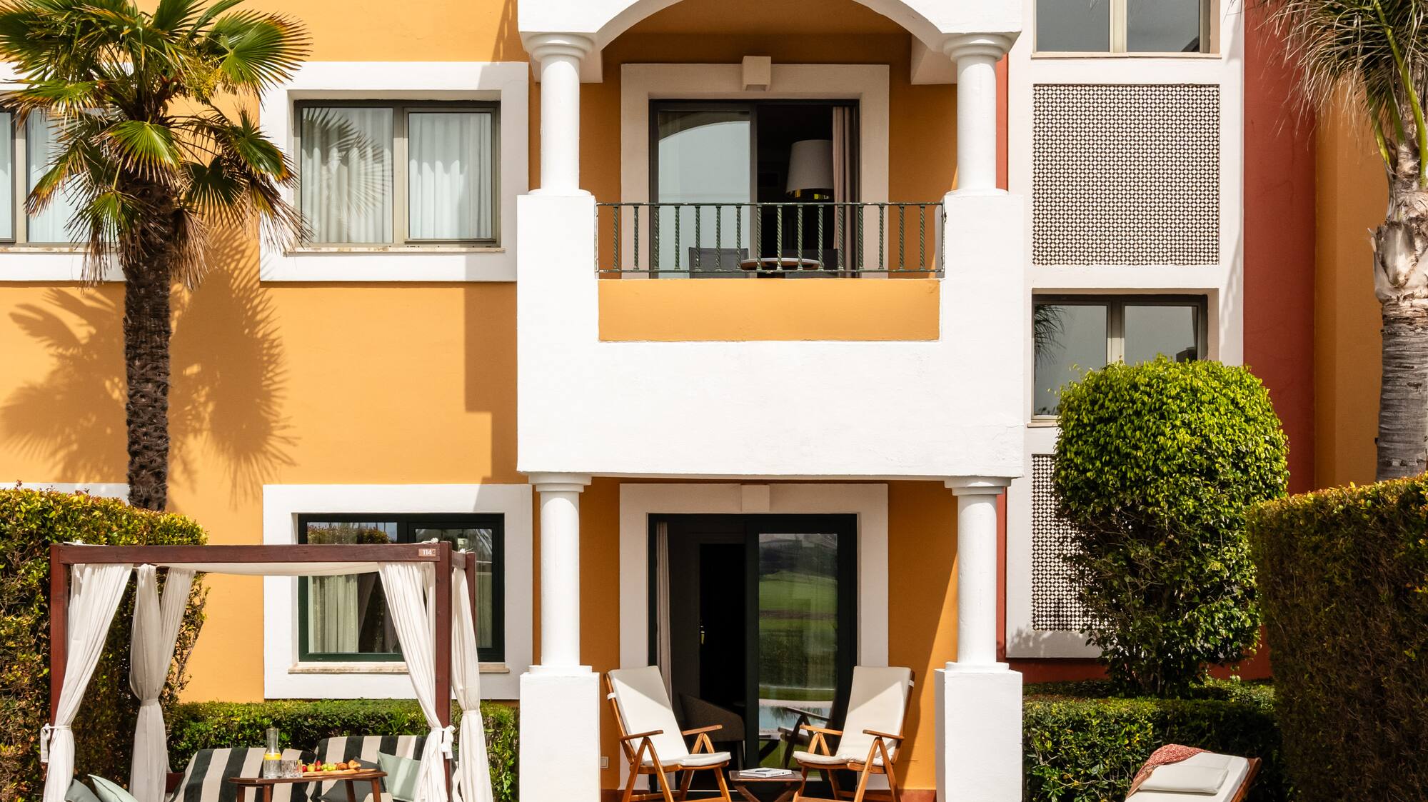 a building with a pool and chairs