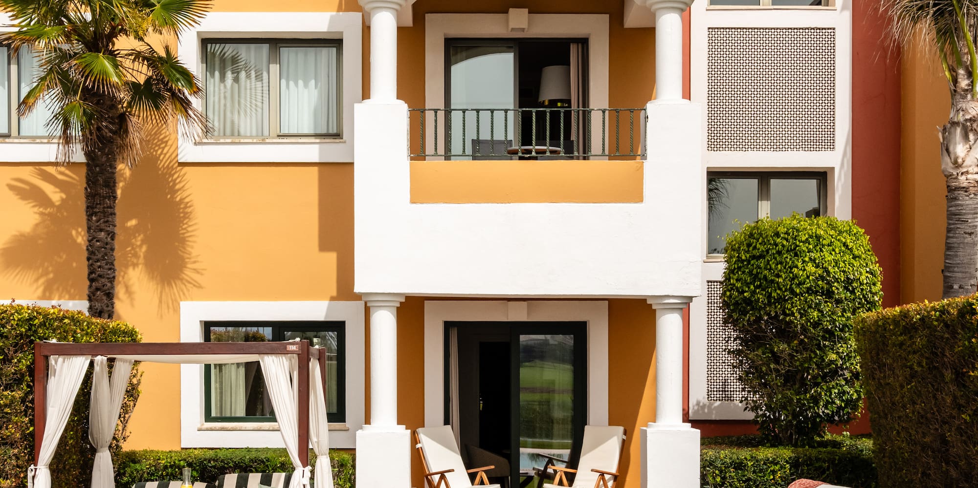 a building with a pool and chairs
