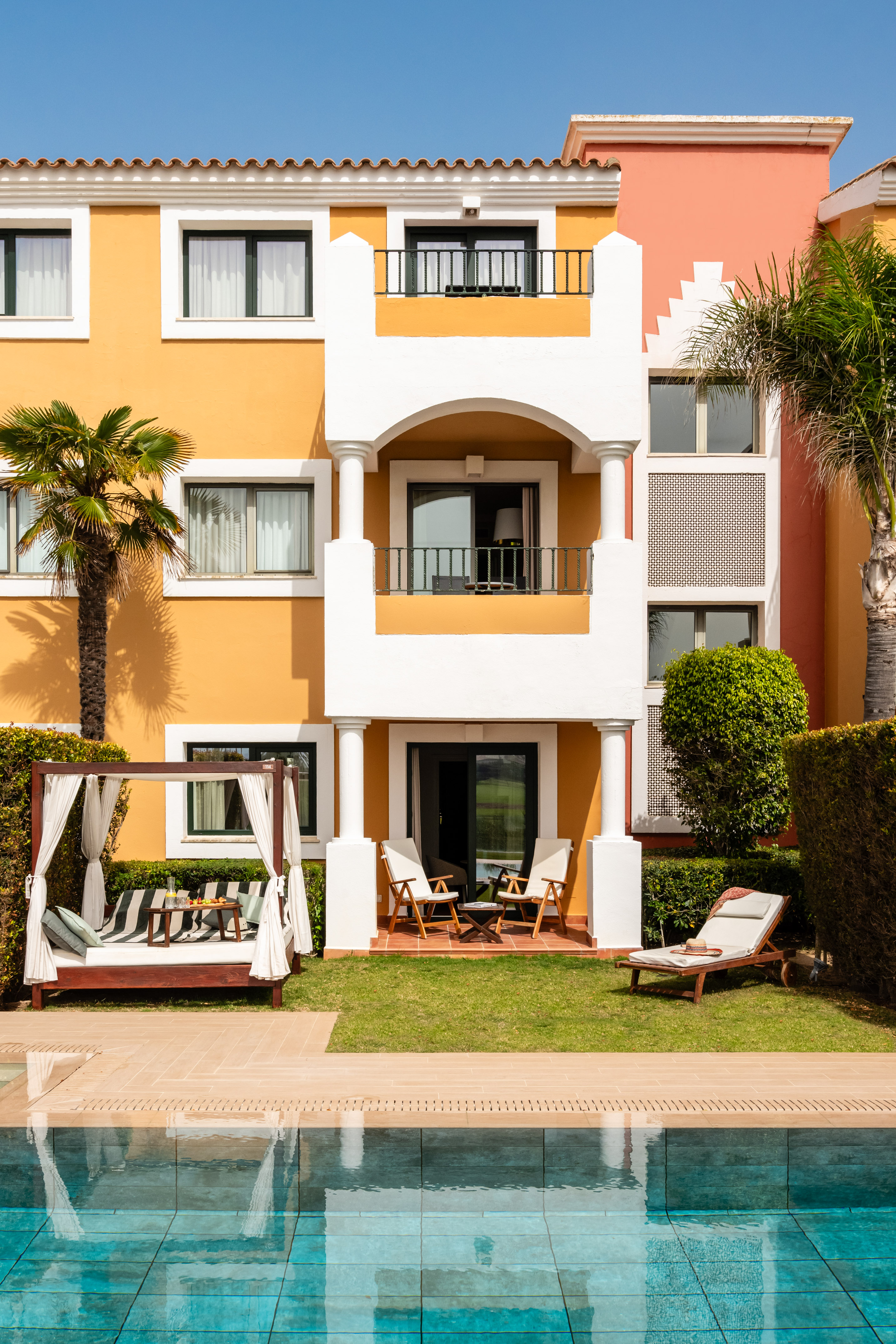 a building with a pool and chairs