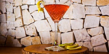 a glass with a drink on a wooden surface