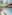Tropical resort pool deck with modern hotel, palm trees, and outdoor lounge.
