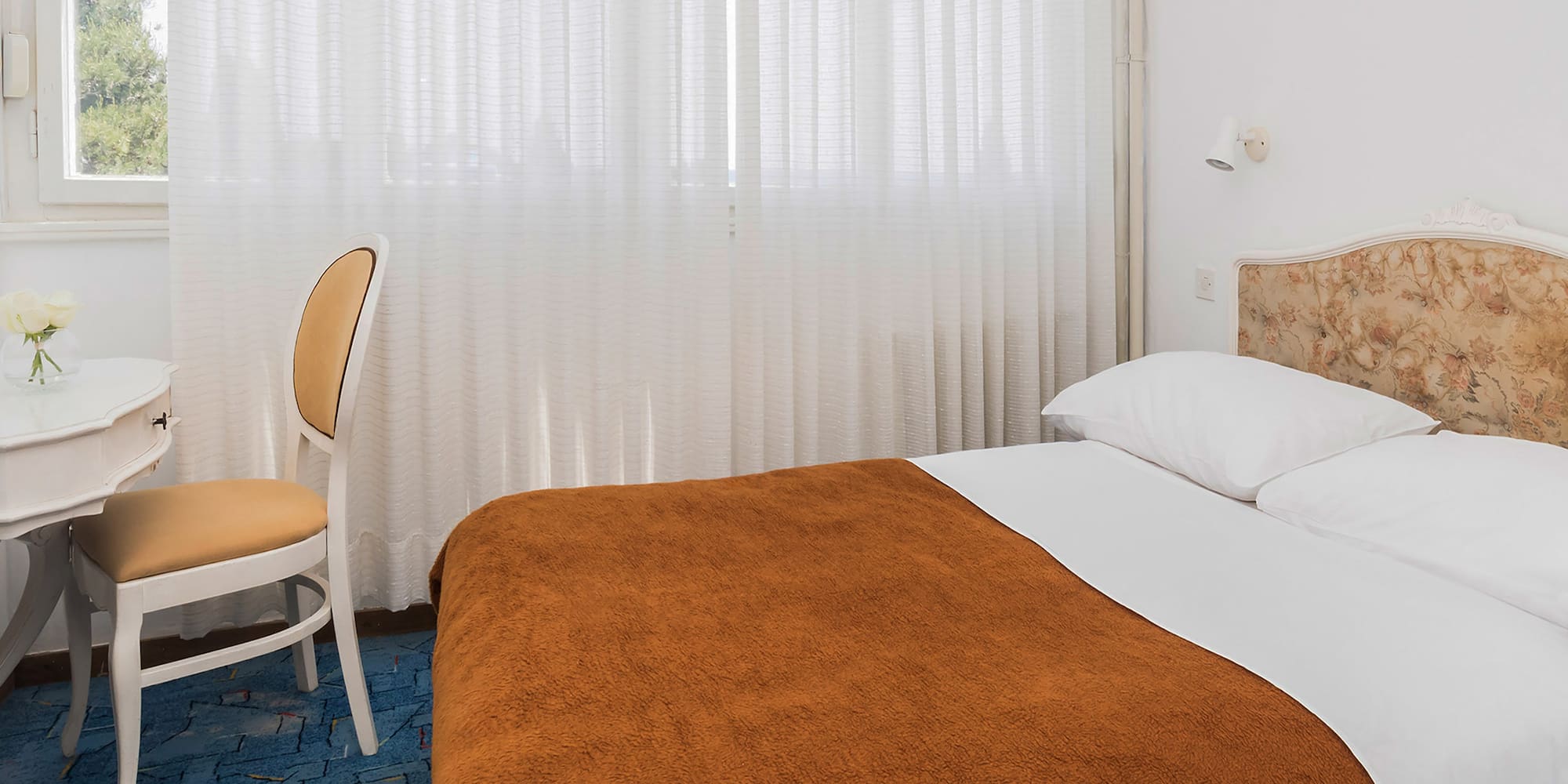 a bed with a chair and a table in a room