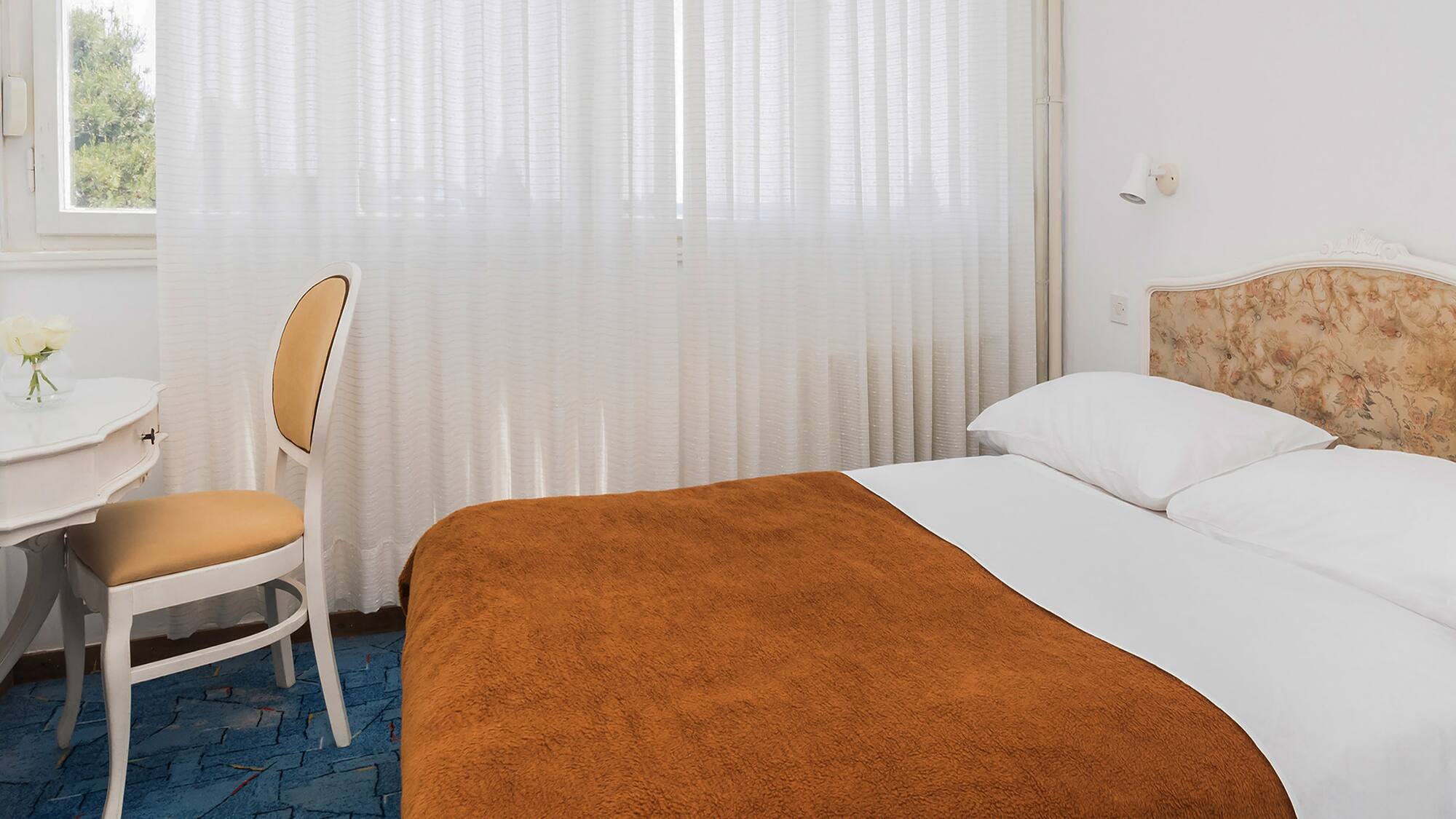 a bed with a chair and a table in a room