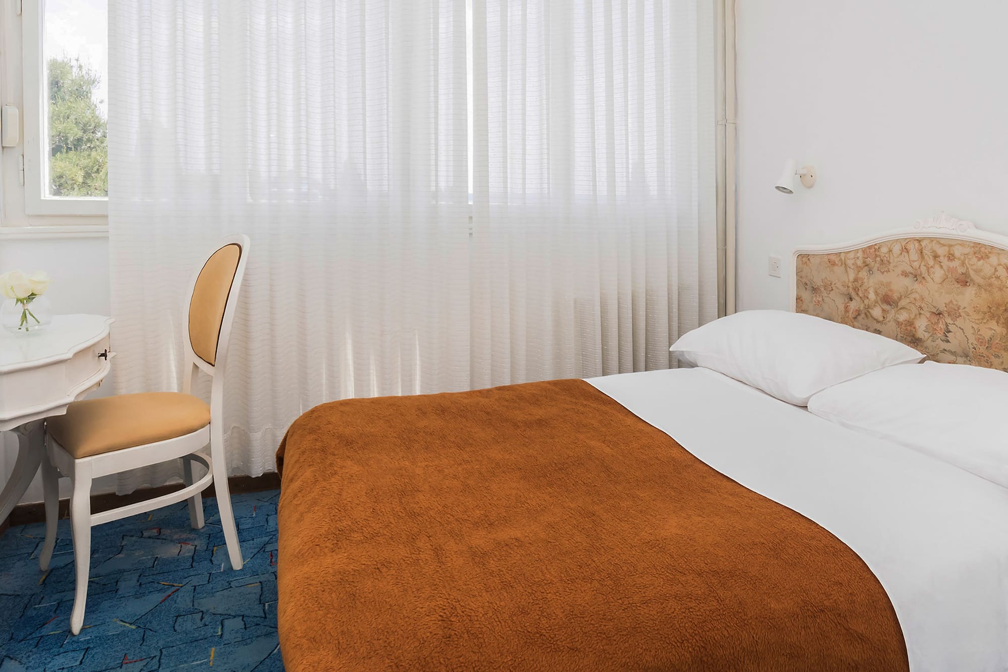 a bed with a chair and a table in a room