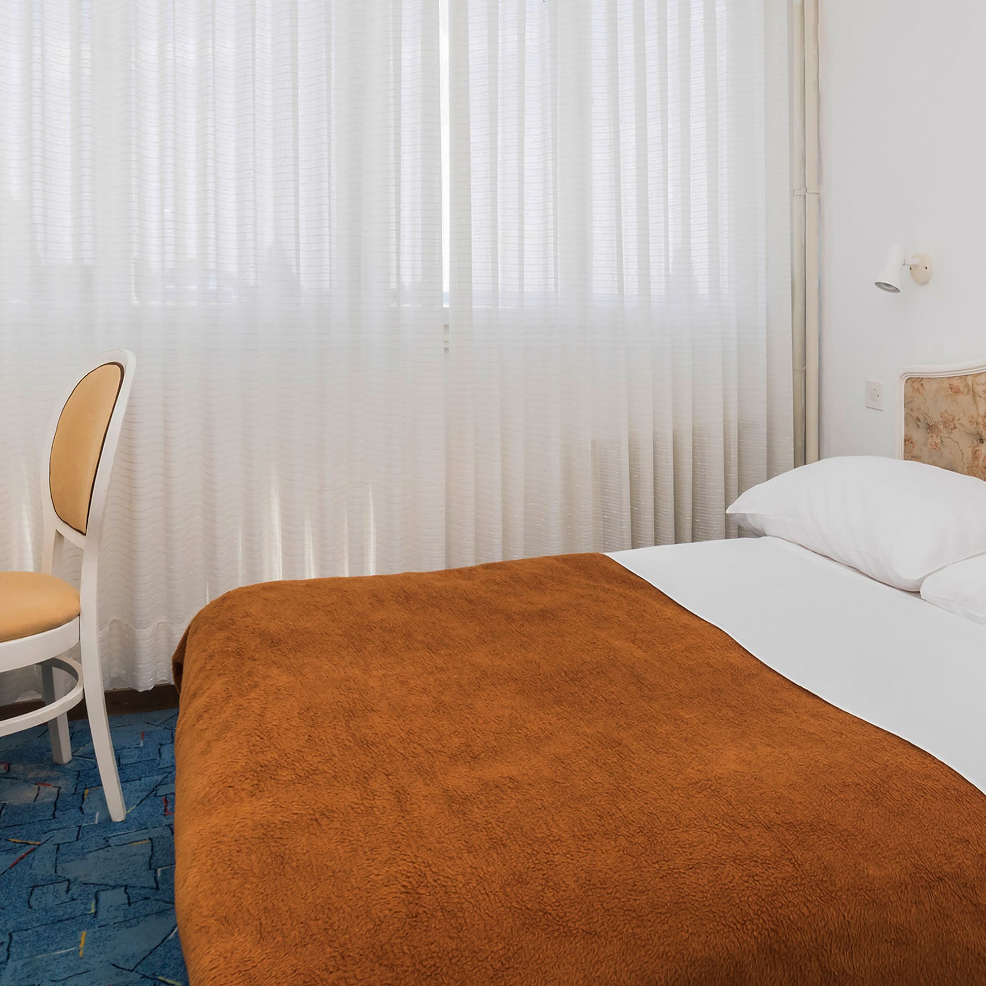 a bed with a chair and a table in a room