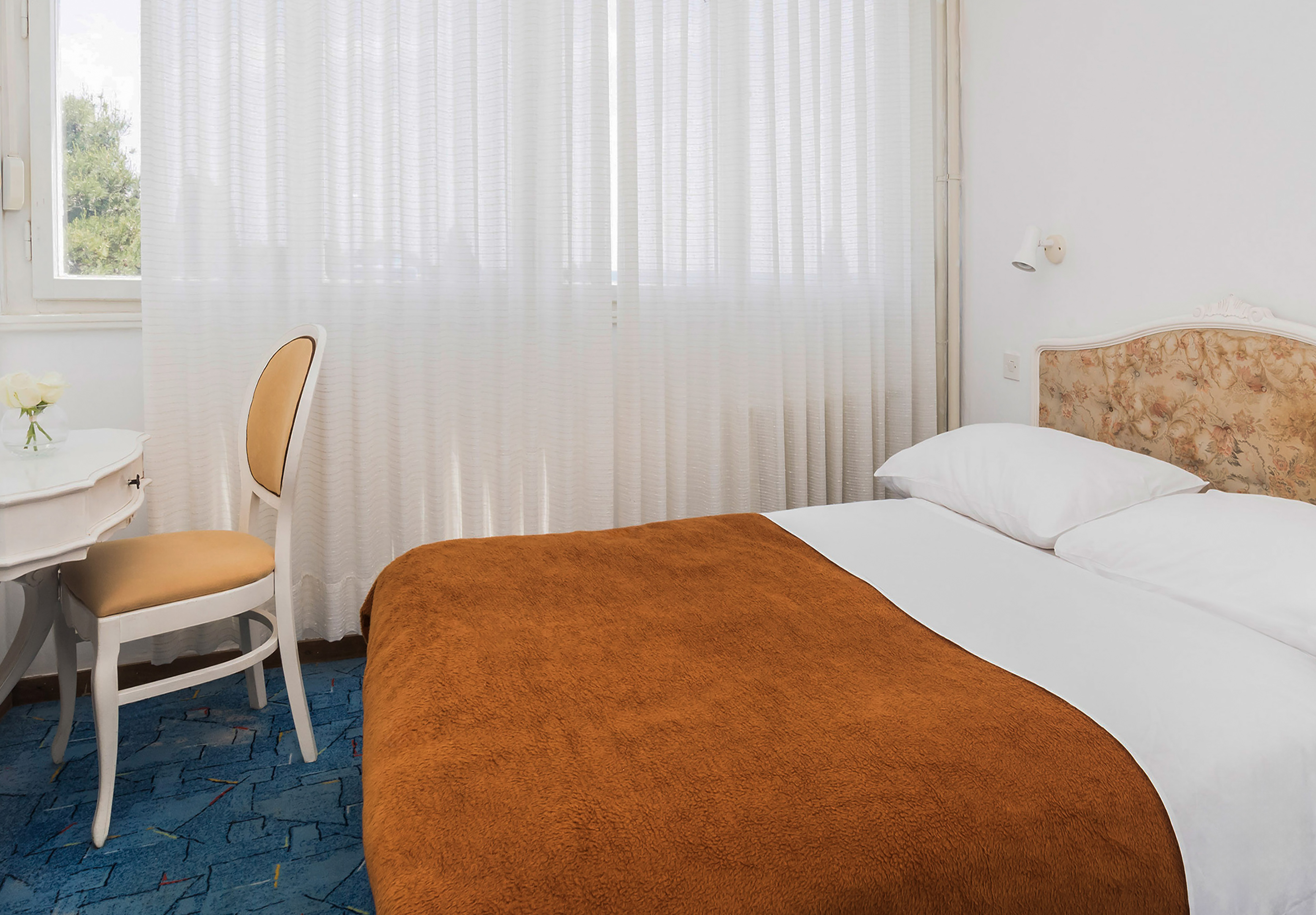 a bed with a chair and a table in a room