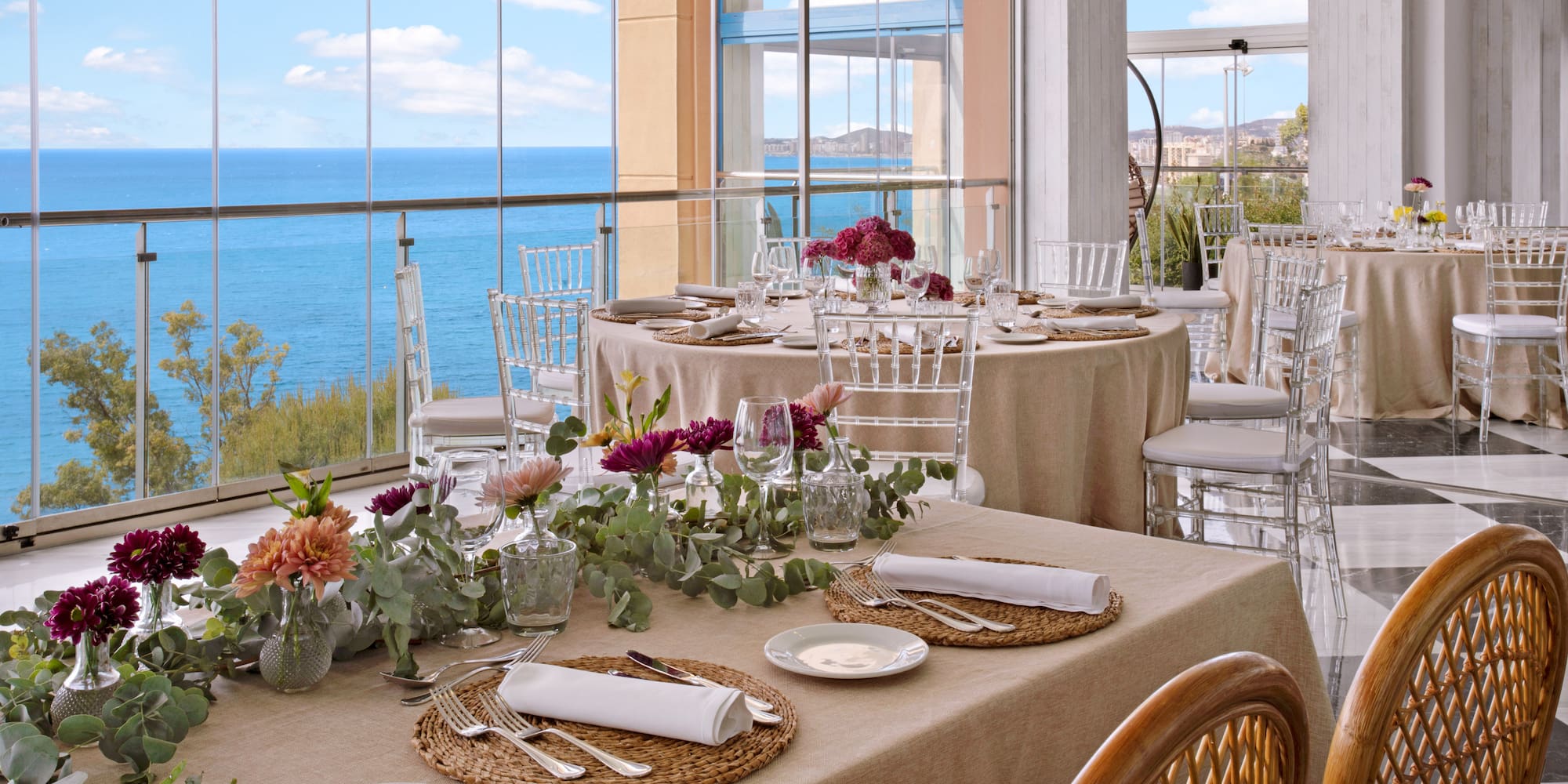 Coastal event dining room with elegant table settings and sea views.