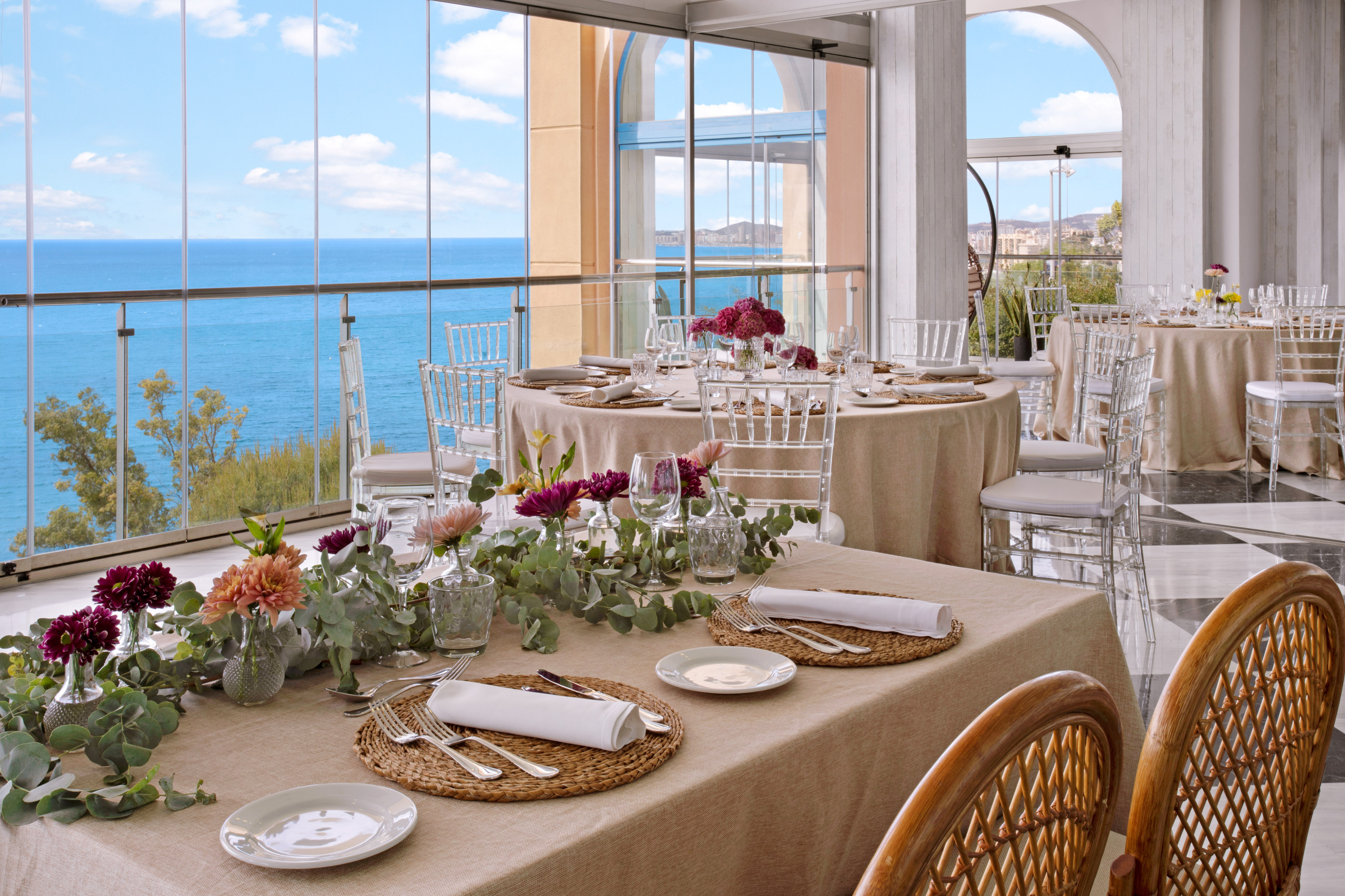 Coastal event dining room with elegant table settings and sea views.