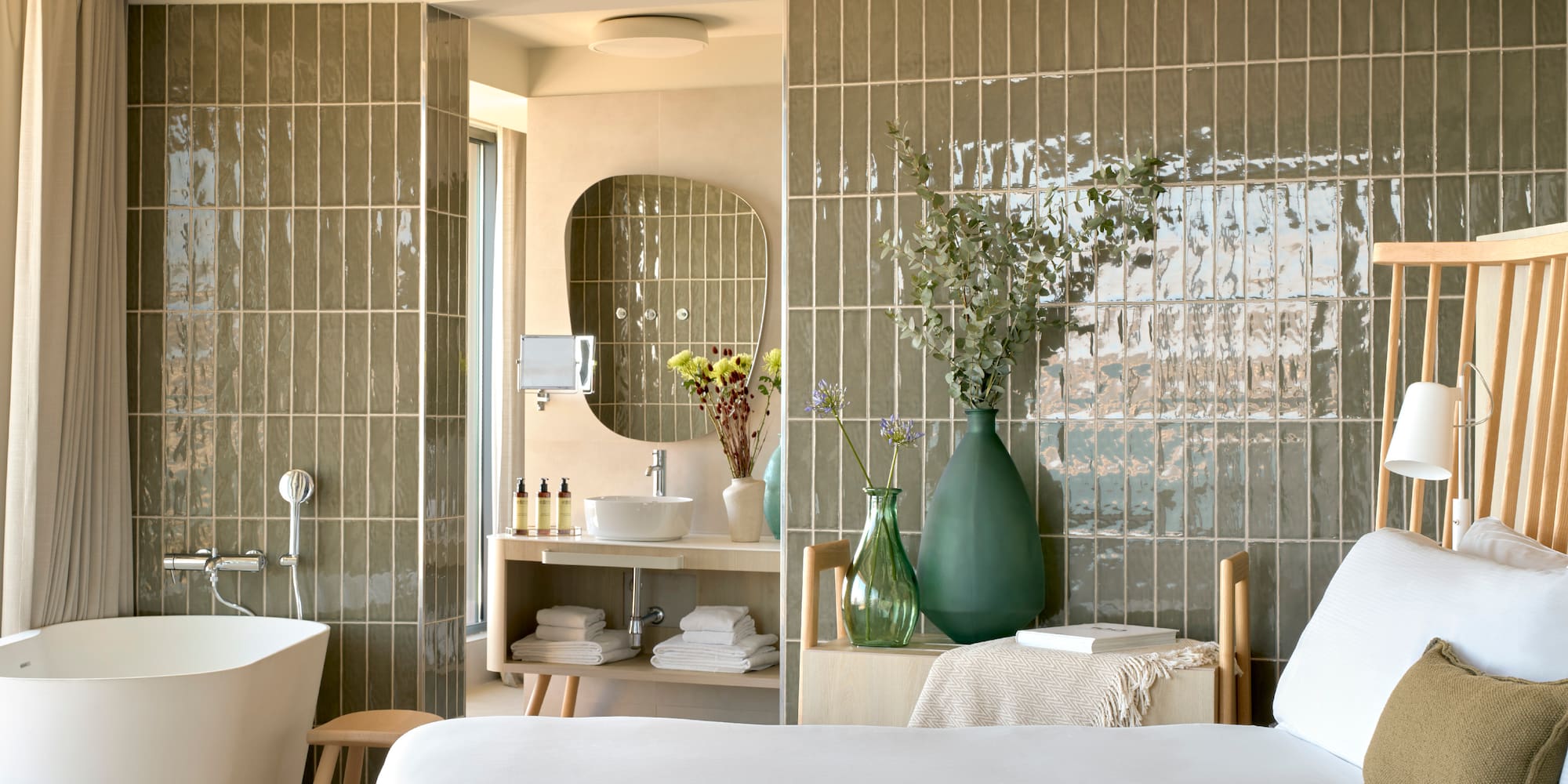 a bathroom with a white bed and a tub