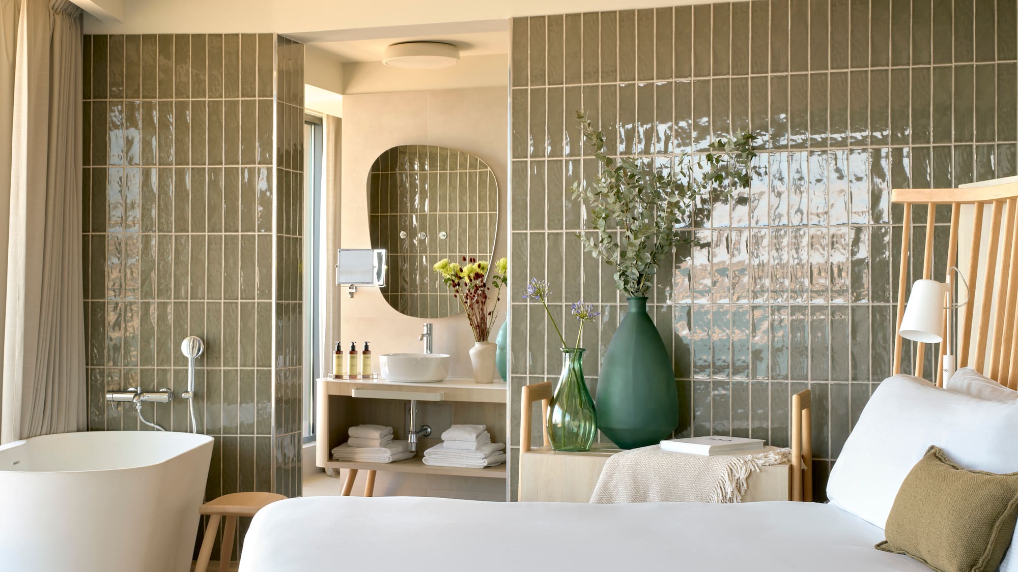 a bathroom with a white bed and a tub