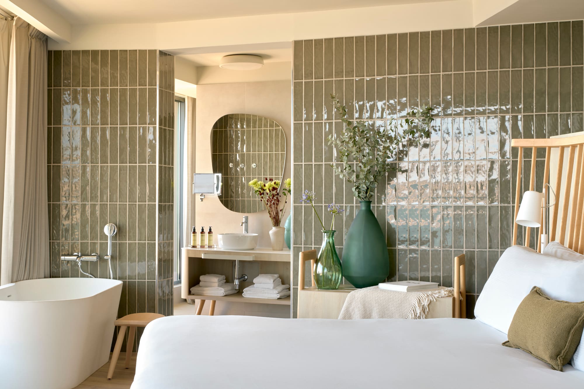 a bathroom with a white bed and a tub