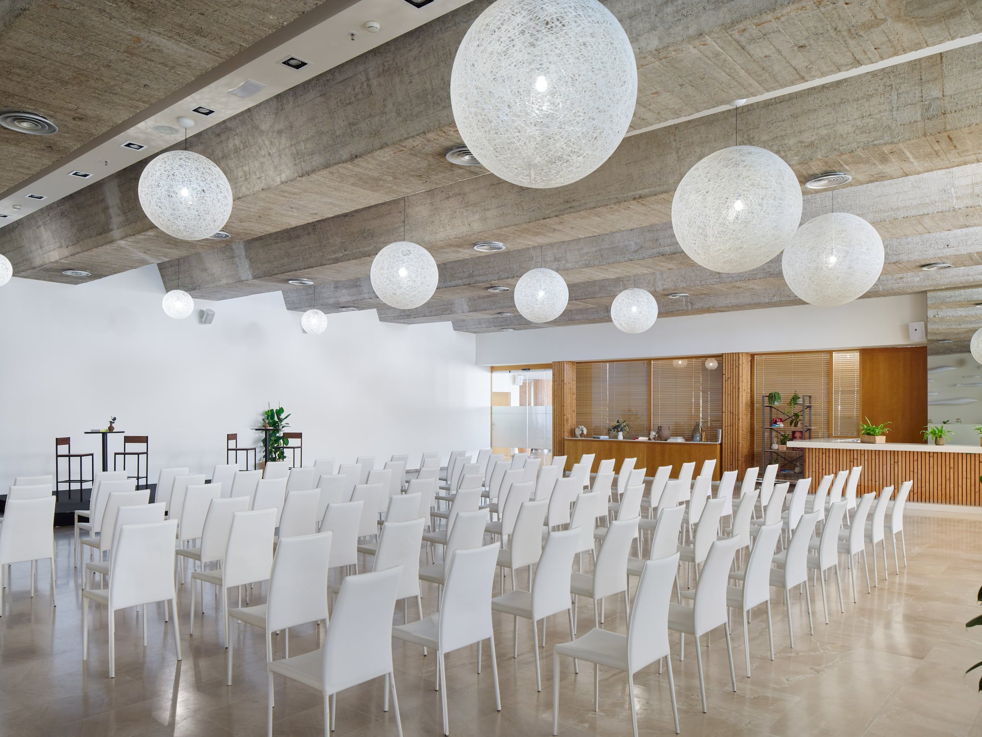 a room with white chairs and white lights