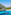 Crystal clear turquoise bay, white sand beach, and rocky pine cliffs.