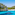Turquoise water beach in a rocky Mediterranean cove with pine trees.