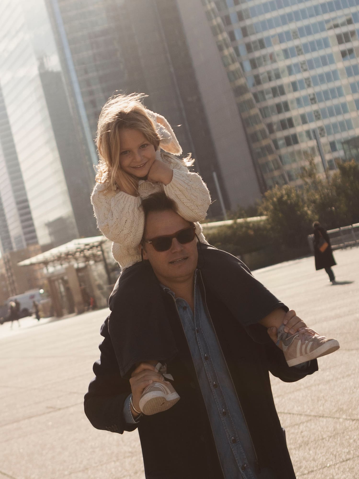 a man carrying a girl on his shoulders