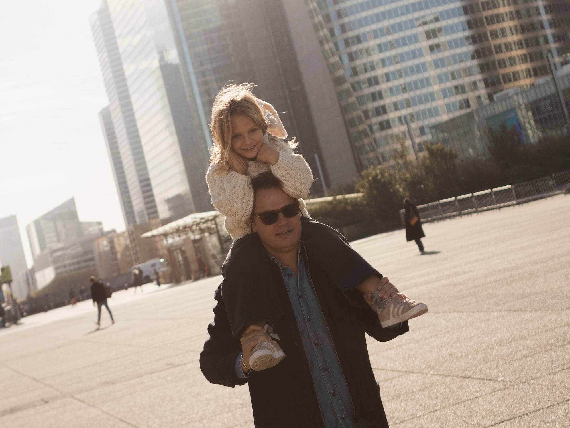 a man carrying a girl on his shoulders