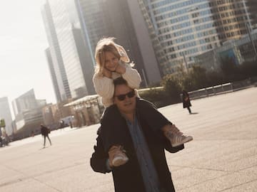 a man carrying a girl on his shoulders