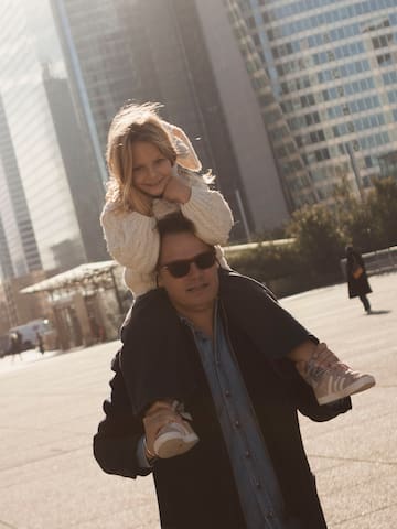 a man carrying a girl on his shoulders